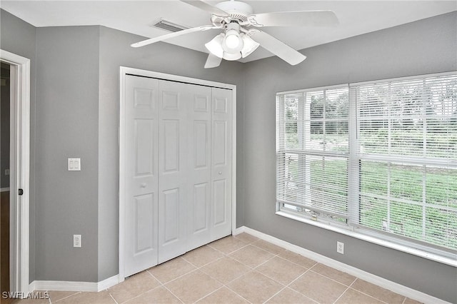4016 35th St SW, Lehigh Acres, FL 33976 - unfurnished bedroom featuring light tile patterned floors, a closet, baseboards, and ceiling fan