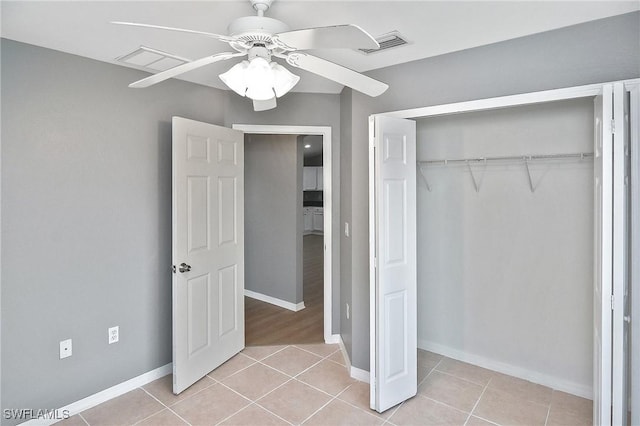 4016 35th St SW, Lehigh Acres, FL 33976 - unfurnished bedroom featuring light tile patterned floors, a closet, and baseboards