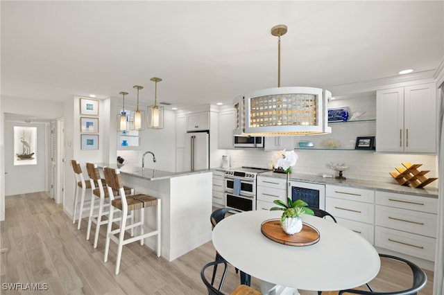 827 E Gulf Dr Unit C6, Sanibel, FL 33957 - kitchen featuring high end appliances, a breakfast bar area, recessed lighting, beverage cooler, and backsplash