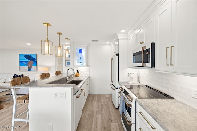 827 E Gulf Dr Unit C6, Sanibel, FL 33957 - kitchen featuring white appliances, a peninsula, white cabinetry, a kitchen bar, and recessed lighting