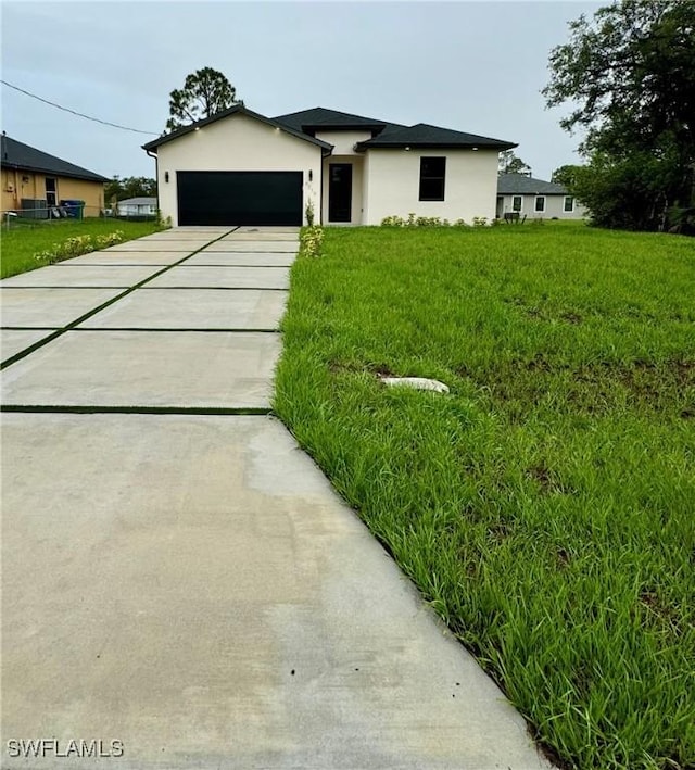 6010 Acorn Cir, Labelle, FL 33935 - view of front of property with stucco siding, concrete driveway, a garage, and a front yard