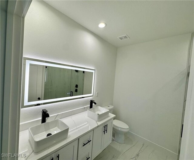 6010 Acorn Cir, Labelle, FL 33935 - full bathroom with toilet, marble finish floors, double vanity, a marble finish shower, and baseboards