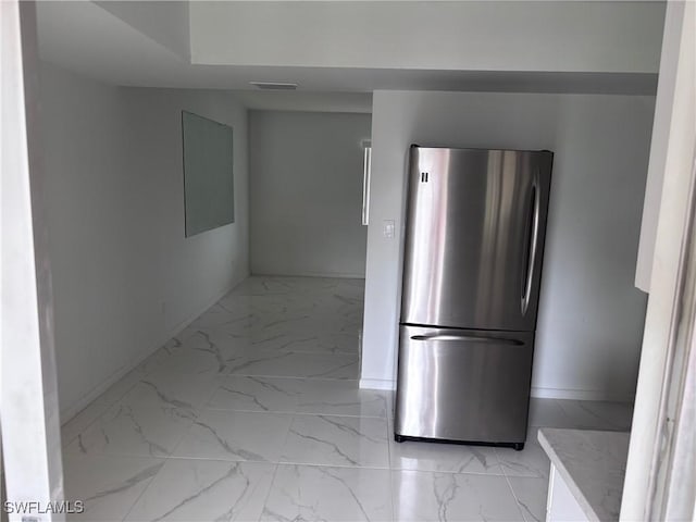 339 Joel Blvd Unit 221, Lehigh Acres, FL 33936 - kitchen featuring freestanding refrigerator, light marble finish flooring, and baseboards