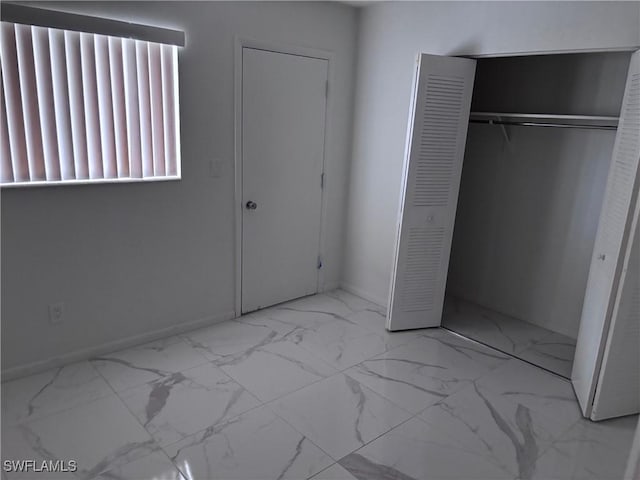 339 Joel Blvd Unit 221, Lehigh Acres, FL 33936 - unfurnished bedroom with marble finish floors, a closet, and baseboards