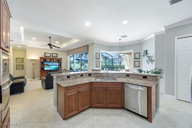 10026 Lions Bay Ct, Naples, FL 34120 - kitchen with appliances with stainless steel finishes, open floor plan, a ceiling fan, light stone counters, and brown cabinetry