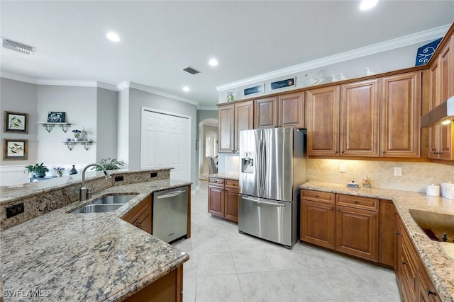 10026 Lions Bay Ct, Naples, FL 34120 - kitchen featuring appliances with stainless steel finishes, crown molding, brown cabinetry, light stone countertops, and recessed lighting