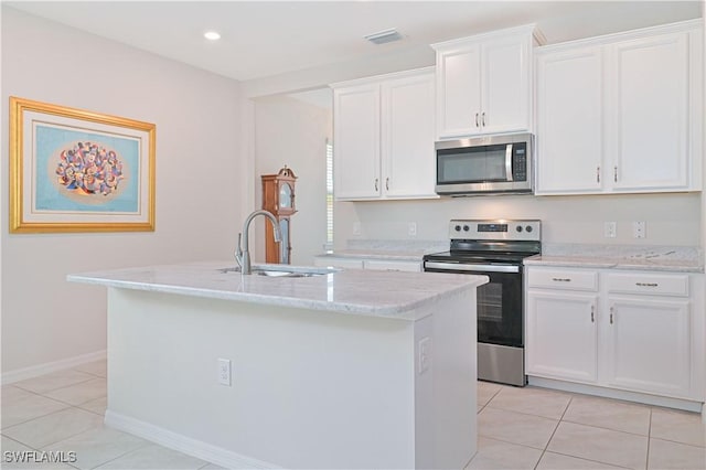 2113 Summersweet Dr, Alva, FL 33920 - kitchen with stainless steel appliances, light tile patterned flooring, a kitchen island with sink, white cabinetry, and light stone countertops