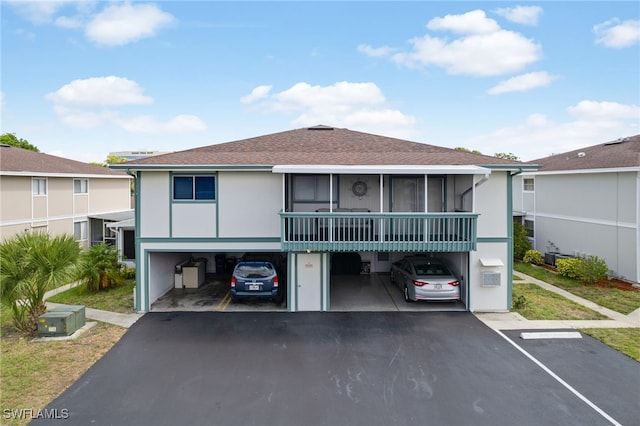 3297 Royal Canadian Trce Unit 2, Fort Myers, FL 33907 - view of front of house featuring roof with shingles, a sunroom, and stucco siding