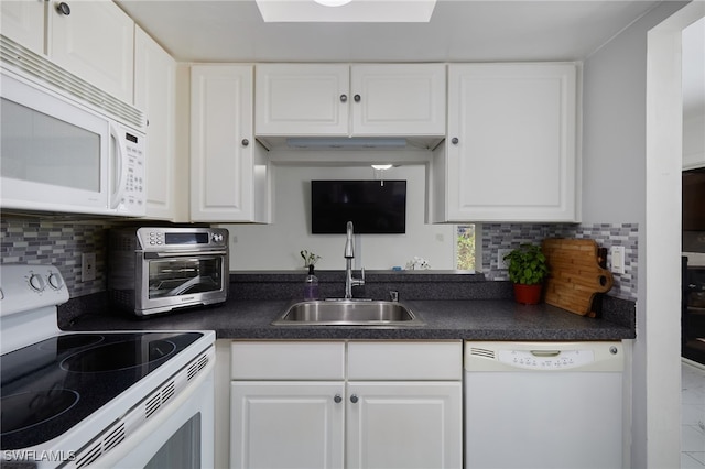 3297 Royal Canadian Trce Unit 2, Fort Myers, FL 33907 - kitchen with white appliances, a sink, dark countertops, white cabinetry, and decorative backsplash