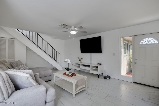 3297 Royal Canadian Trce Unit 2, Fort Myers, FL 33907 - living room featuring light marble finish floors, ceiling fan, and stairs
