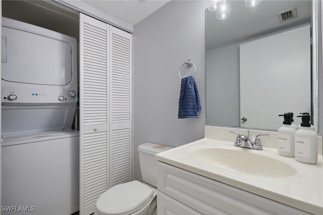 3297 Royal Canadian Trce Unit 2, Fort Myers, FL 33907 - bathroom with stacked washer / dryer, a closet, toilet, and vanity