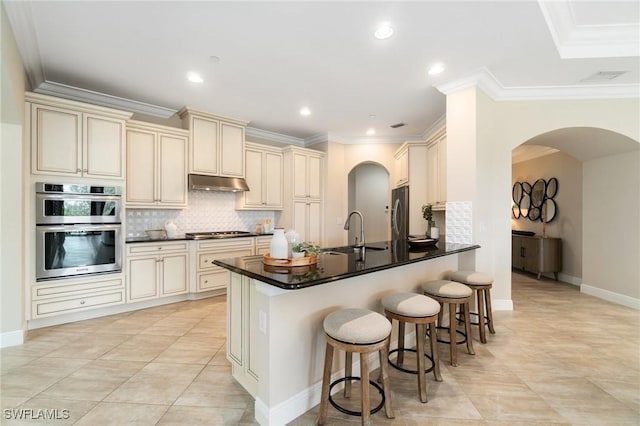 2768 Tiburon Blvd E Unit 202, Naples, FL 34109 - kitchen featuring cream cabinetry, a sink, stainless steel appliances, a peninsula, and ornamental molding