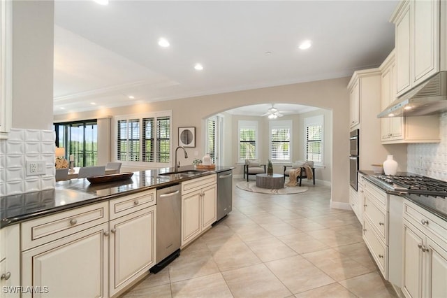 2768 Tiburon Blvd E Unit 202, Naples, FL 34109 - kitchen featuring a sink, dark countertops, stainless steel appliances, open floor plan, and arched walkways