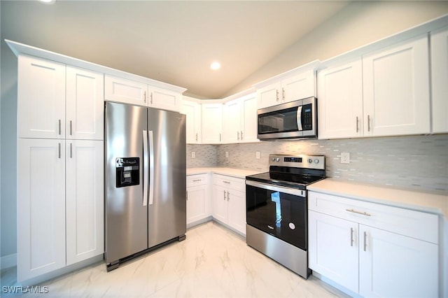 128 Sanborn Dr, Lehigh Acres, FL 33972 - kitchen with stainless steel appliances, decorative backsplash, light countertops, light marble finish flooring, and lofted ceiling