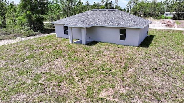 128 Sanborn Dr, Lehigh Acres, FL 33972 - exterior space featuring a yard, stucco siding, and roof with shingles