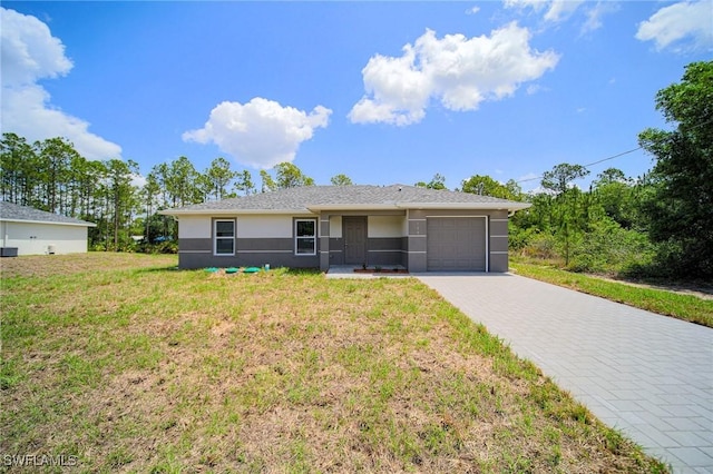 128 Sanborn Dr, Lehigh Acres, FL 33972 - ranch-style home with a garage, decorative driveway, stucco siding, and a front lawn