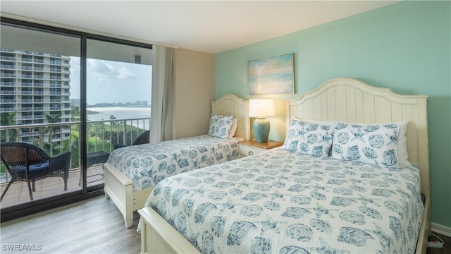 440 Seaview Ct Unit 611, Marco Island, FL 34145 - bedroom with access to outside, expansive windows, wood finished floors, and a water view