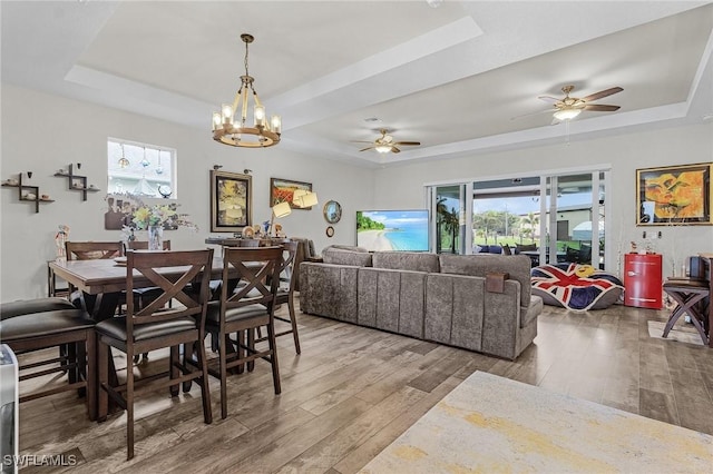 2220 Isle Of Pines Ave, Fort Myers, FL 33905 - dining space featuring a tray ceiling, wood finished floors, a ceiling fan, and a chandelier