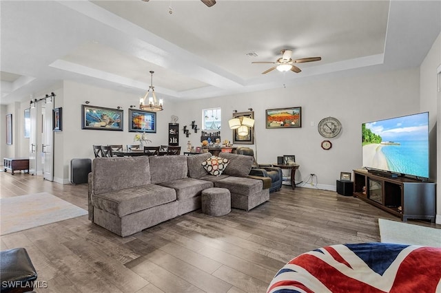 2220 Isle Of Pines Ave, Fort Myers, FL 33905 - living room featuring a raised ceiling, a ceiling fan, wood finished floors, and a chandelier