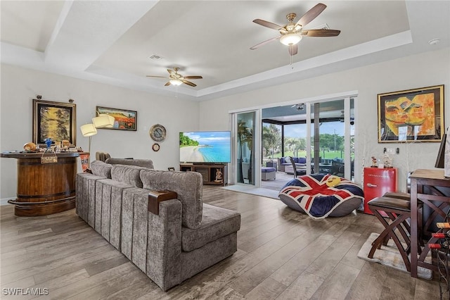 2220 Isle Of Pines Ave, Fort Myers, FL 33905 - living area featuring a tray ceiling, a ceiling fan, and light wood-type flooring