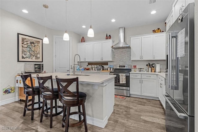 2220 Isle Of Pines Ave, Fort Myers, FL 33905 - kitchen with stainless steel appliances, wall chimney exhaust hood, a sink, light countertops, and light wood finished floors