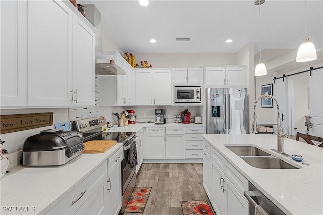 2220 Isle Of Pines Ave, Fort Myers, FL 33905 - kitchen with appliances with stainless steel finishes, a sink, a barn door, white cabinets, and recessed lighting