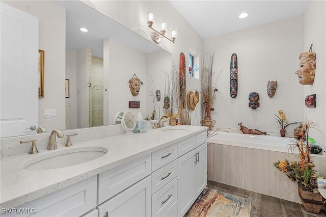 2220 Isle Of Pines Ave, Fort Myers, FL 33905 - bathroom featuring double vanity, a bath, a stall shower, wood finished floors, and recessed lighting