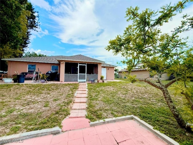 29 Alabama Rd N, Lehigh Acres, FL 33936 - view of front of property featuring stucco siding, a sunroom, a front yard, and a patio area