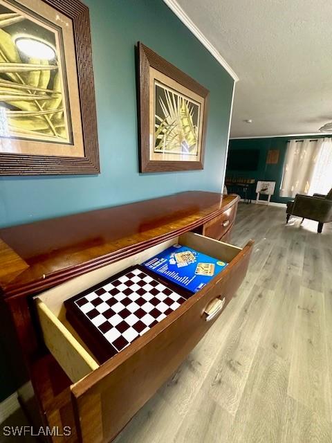 261 Redlin St, North Fort Myers, FL 33903 - recreation room featuring wood finished floors, a textured ceiling, and ornamental molding
