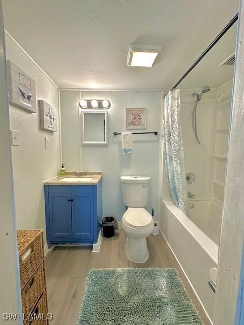 261 Redlin St, North Fort Myers, FL 33903 - full bath featuring wood finished floors, toilet, vanity, and shower / bath combo with shower curtain