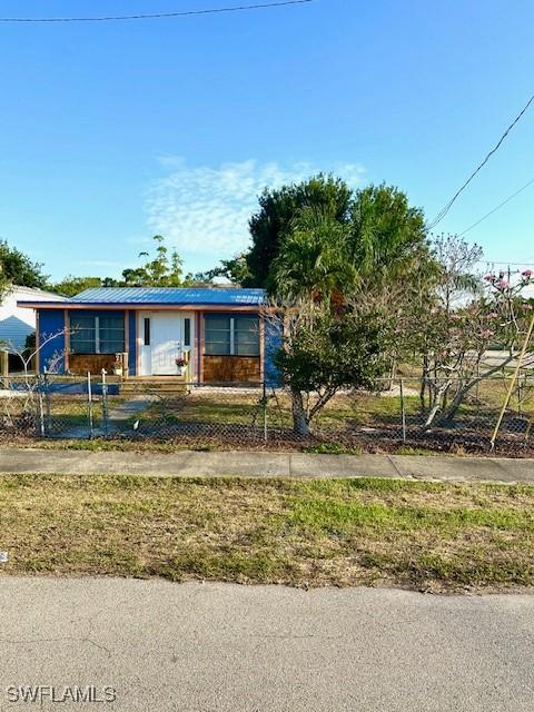 261 Redlin St, North Fort Myers, FL 33903 - manufactured / mobile home featuring a fenced front yard and metal roof