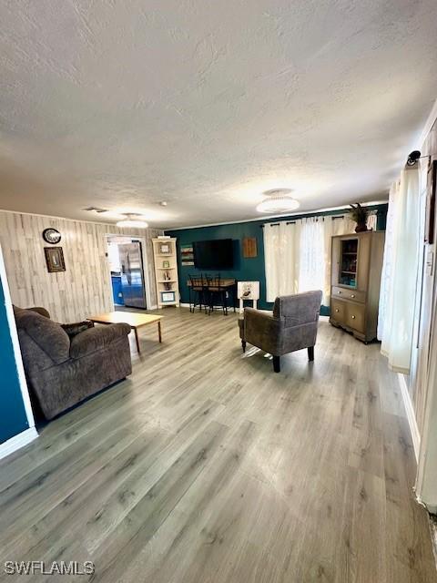 261 Redlin St, North Fort Myers, FL 33903 - living area featuring a textured ceiling, light wood finished floors, and wood walls