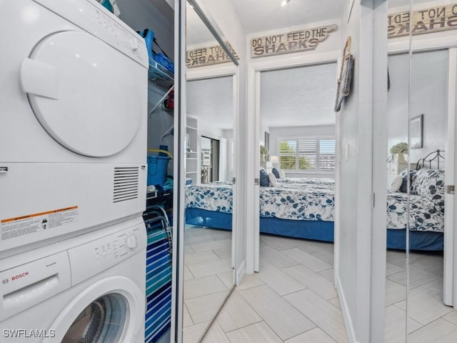 1019 Anglers Cv Unit F302, Marco Island, FL 34145 - laundry area featuring stacked washing machine and dryer and light tile patterned floors