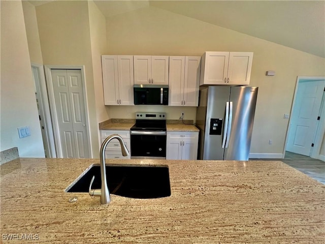 3319 17th St W, Lehigh Acres, FL 33971 - kitchen featuring stainless steel appliances, lofted ceiling, light stone counters, white cabinets, and a sink