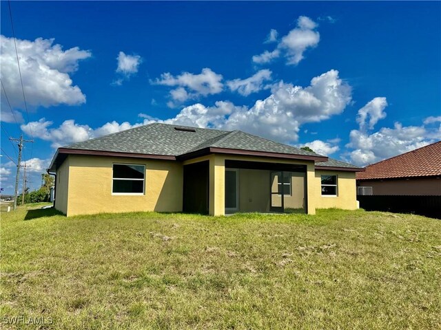 3319 17th St W, Lehigh Acres, FL 33971 - rear view of property with stucco siding, a yard, and roof with shingles