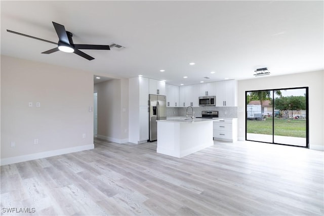 4779 31st Pl SW, Naples, FL 34116 - kitchen featuring stainless steel appliances, open floor plan, light countertops, white cabinets, and light wood finished floors