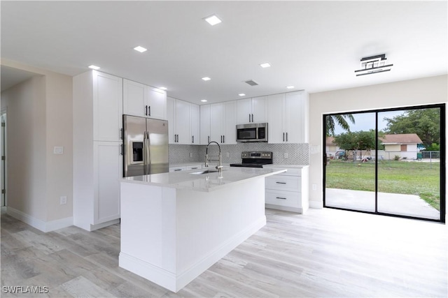 4779 31st Pl SW, Naples, FL 34116 - kitchen with stainless steel appliances, tasteful backsplash, light wood-style floors, white cabinetry, and recessed lighting