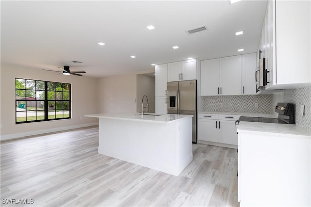 4779 31st Pl SW, Naples, FL 34116 - kitchen featuring appliances with stainless steel finishes, a sink, decorative backsplash, a kitchen island with sink, and light countertops