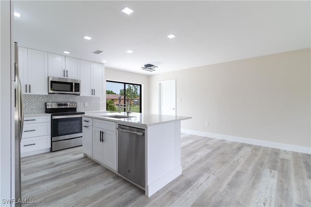 4779 31st Pl SW, Naples, FL 34116 - kitchen featuring stainless steel appliances, a sink, light wood-style flooring, backsplash, and recessed lighting