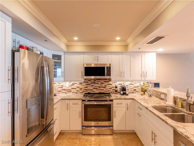 100 N Collier Blvd Unit 803, Marco Island, FL 34145 - kitchen with appliances with stainless steel finishes, ornamental molding, decorative backsplash, white cabinetry, and light stone counters