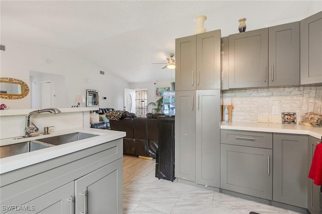 503 E 13th St, Lehigh Acres, FL 33972 - kitchen featuring gray cabinets, a sink, vaulted ceiling, backsplash, and light countertops