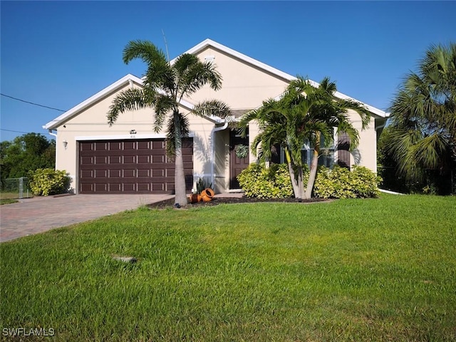 406 SW 25th Pl, Cape Coral, FL 33991 - view of front of property with a garage, decorative driveway, a front yard, and stucco siding