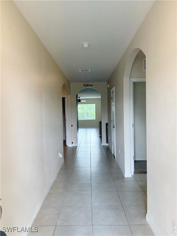 406 SW 25th Pl, Cape Coral, FL 33991 - hall featuring arched walkways, light tile patterned floors, and baseboards
