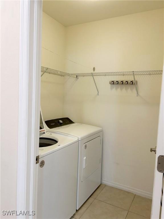 406 SW 25th Pl, Cape Coral, FL 33991 - washroom with washing machine and clothes dryer, light tile patterned floors, and baseboards