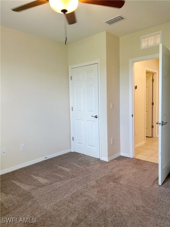 406 SW 25th Pl, Cape Coral, FL 33991 - unfurnished bedroom with carpet flooring, baseboards, and a ceiling fan