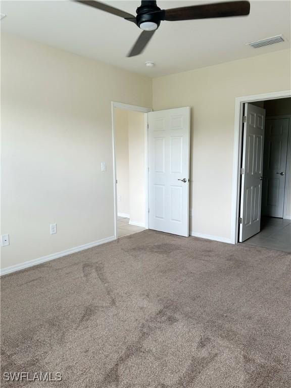 406 SW 25th Pl, Cape Coral, FL 33991 - unfurnished bedroom with carpet, baseboards, and ceiling fan