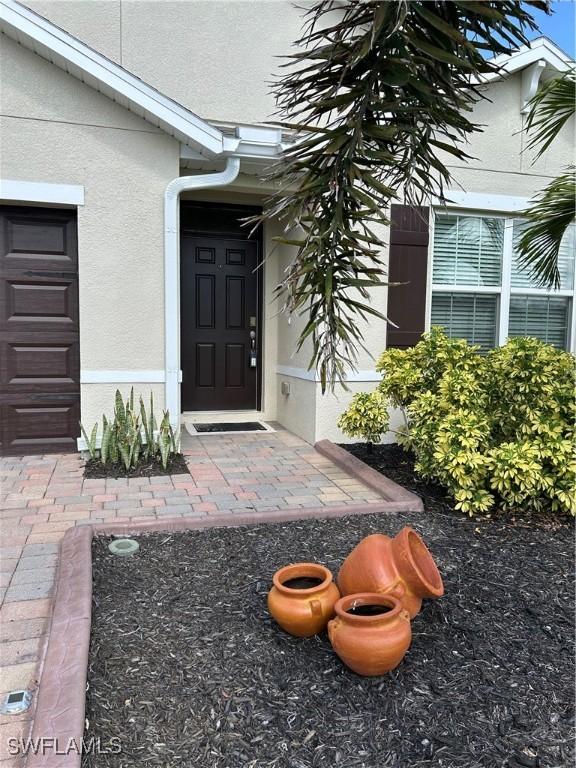 406 SW 25th Pl, Cape Coral, FL 33991 - doorway to property with stucco siding