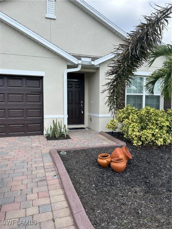 406 SW 25th Pl, Cape Coral, FL 33991 - doorway to property with stucco siding and a garage