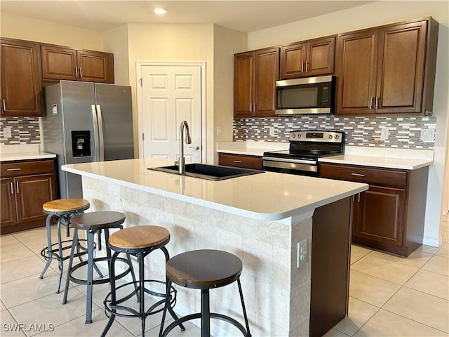 406 SW 25th Pl, Cape Coral, FL 33991 - kitchen with stainless steel appliances, a sink, light tile patterned floors, backsplash, and a breakfast bar