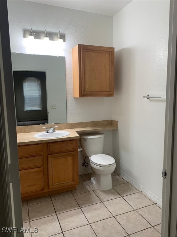 6169 Metrowest Blvd Unit 104, Orlando, FL 32835 - bathroom featuring vanity, tile patterned floors, and toilet